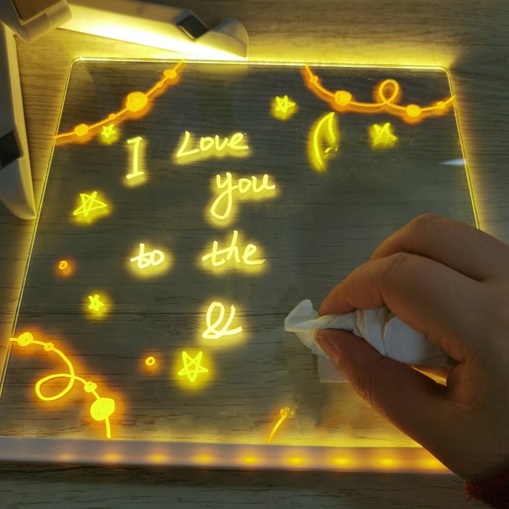 Hand wiping erasable writing from the illuminated acrylic drawing board