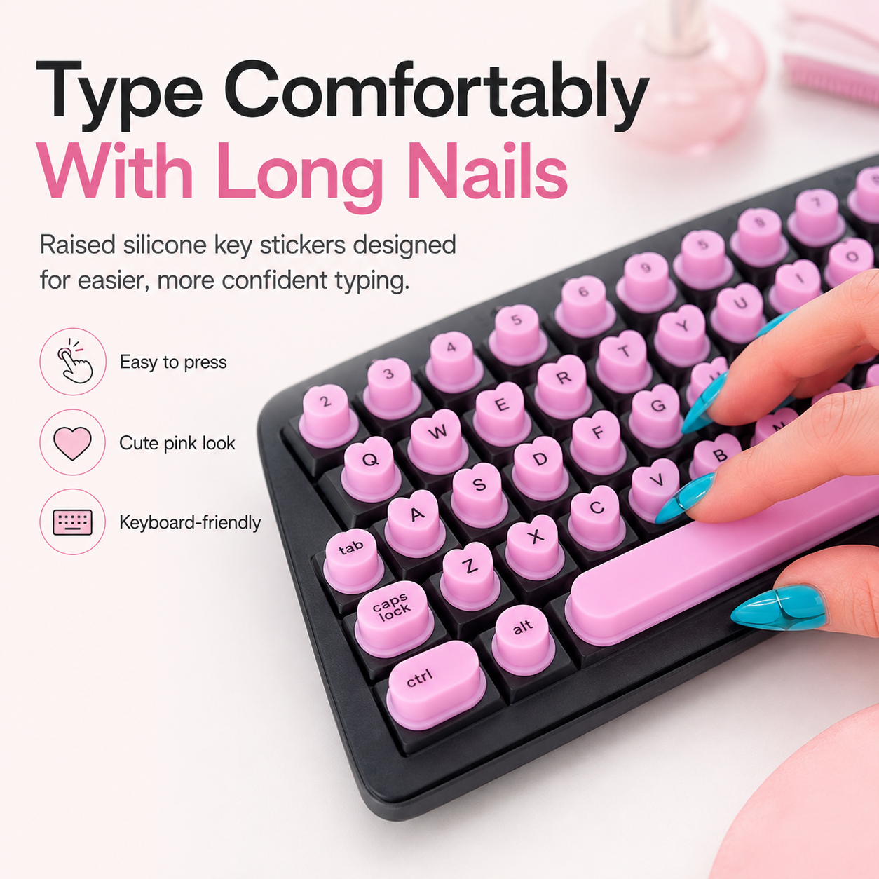 Typing on raised pink silicone keyboard toppers with long blue acrylic nails