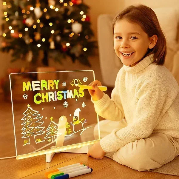Child drawing colorful Christmas artwork on a glowing LED drawing board